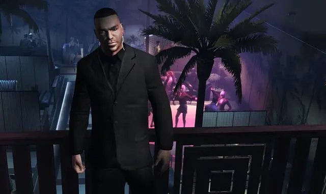 Luis Lopez in a black suit leaning on the railing of a mezzanine overlooking the dance floor of a nightclub lit by pink and purple neon in The Ballad of Gay Tony
