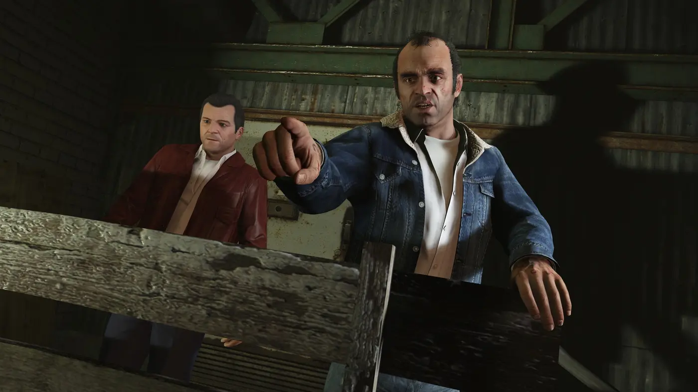 Trevor pointing his finger, Michael standing behind him in a hangar, in GTA 5