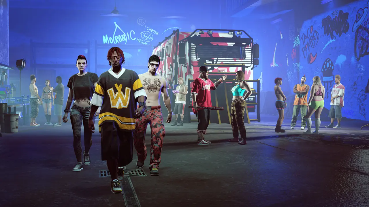 The inside of the Freakshop in GTA Online, a warehouse lit with blue neon and covered in graffiti, with the Fooligans crew walking toward the camera and the red-and-white camo Brickade 6x6 truck parked in the back
