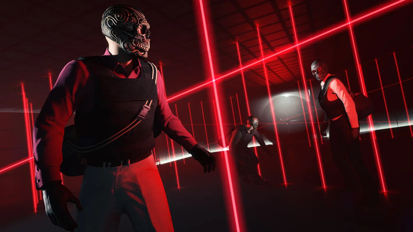 Official GTA Online screenshot: three robbers in stylized skull masks, wearing body armor with duffel bags slung across their shoulders, moving through a room completely gridded with vertical and horizontal red laser beams