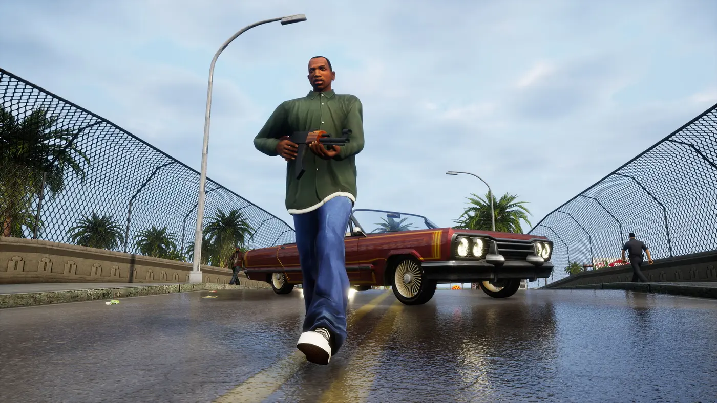 Carl CJ Johnson, in a green shirt with a rifle in hand, walks toward the camera in front of a red lowrider on a fenced San Andreas bridge