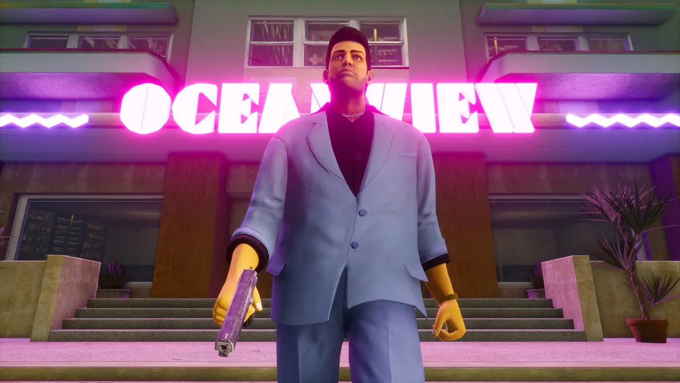 Tommy Vercetti in a light blue suit, pistol in hand, in front of the pink neon sign of the Ocean View hotel in Vice City