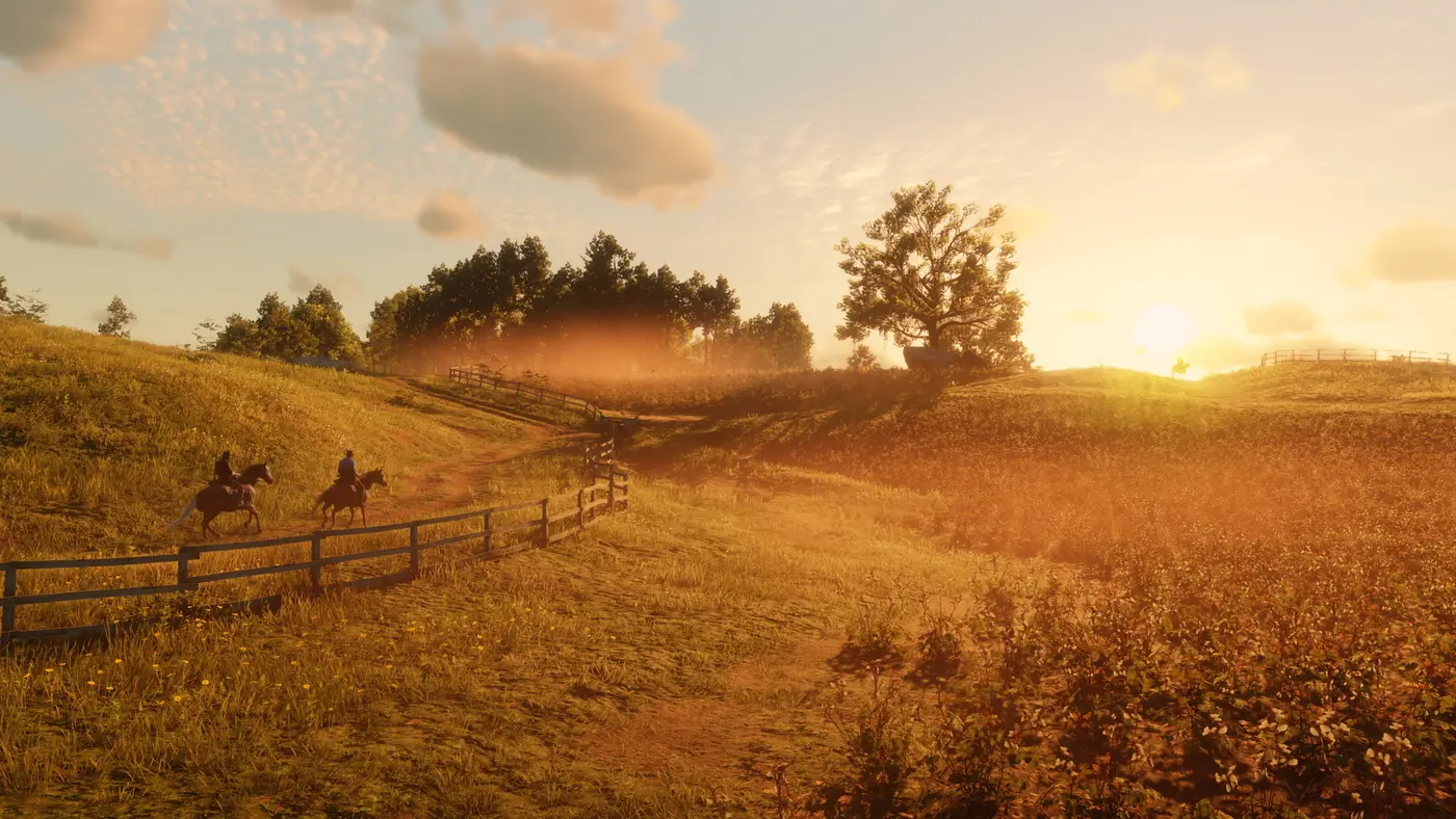 Two riders following a wooden fence along a rolling prairie trail at sunset in Red Dead Redemption 2, a lone tree on the ridge and a golden haze